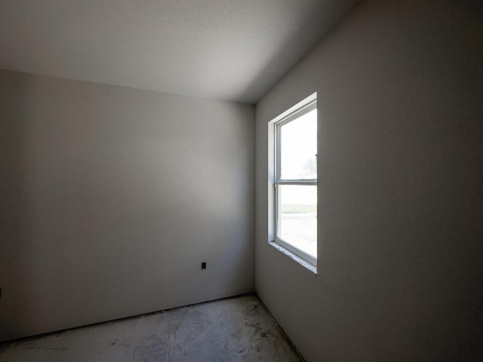 Lege kamer met strakke grijze muren, een wit plafond en een raam